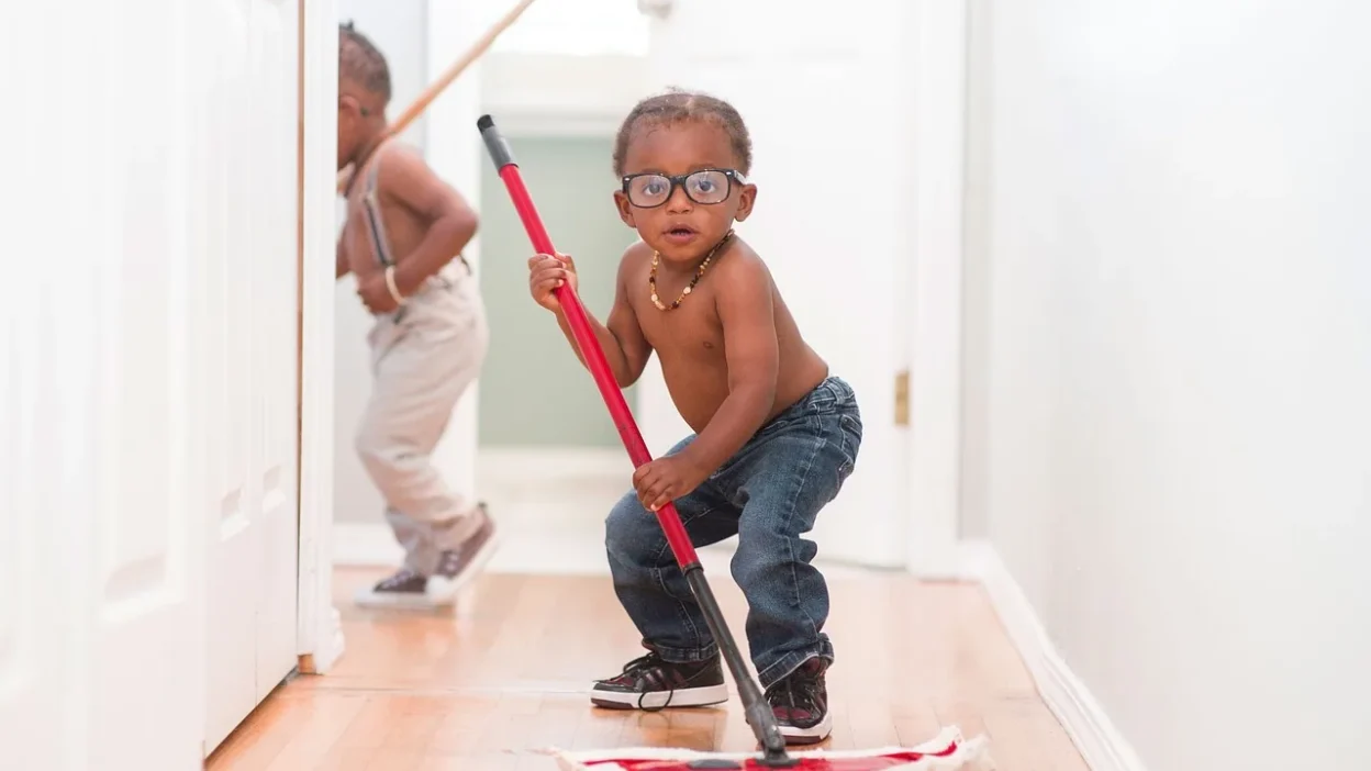 Person making common cleaning mistakes like using dirty tools and mixing chemicals in a messy kitchen.