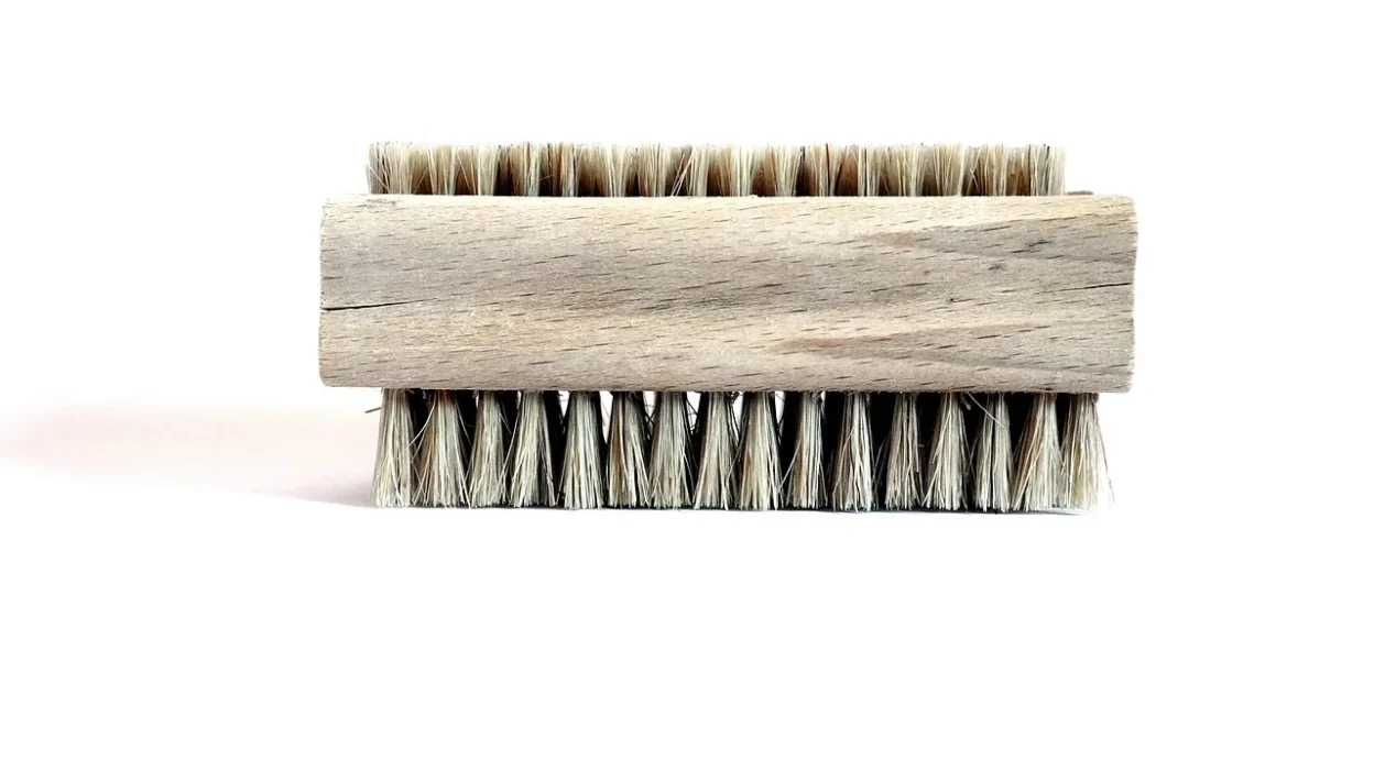 Worn-out scrub brush with frayed bristles next to a checklist for replacement.