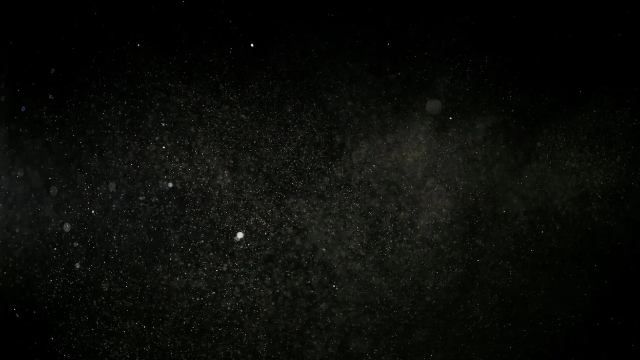 Person dusting a windowsill with a microfiber cloth to prevent dust from returning quickly.